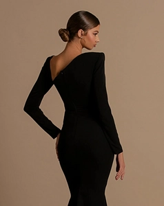 Detail of a slim-fit black mermaid dress with cut-out back and elegant long sleeves