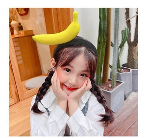 Funny giant yellow banana headband for kids shown on a smiling girl with braids