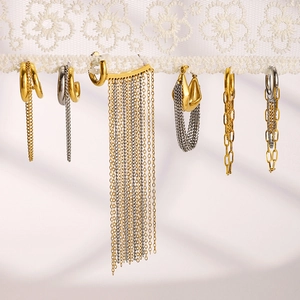 Elegant gold and silver tassel earrings and ear cuffs on delicate white lace