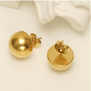 Detailed view of gold hemispherical stud earrings with butterfly backings and polished finish