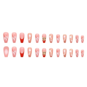 Pink press-on nails set with floral patterns and 3D gold heart rhinestones on white background