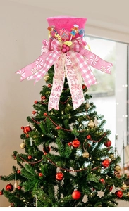 Close-up of pink gingerbread man hat topper with plaid bow on a Christmas tree