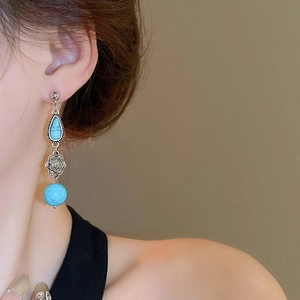 Detail of vintage turquoise style earrings with silver flower and droplet pendants