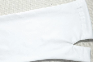 Detail shot of white sun protection arm sleeve featuring functional thumb hole design