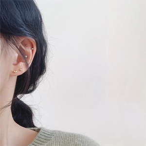 Minimalist 925 sterling silver heart and ball stud earrings set on a female model