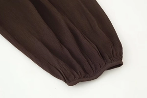 Détail de la manchette de chemisier marron foncé avec texture mousseline drapée