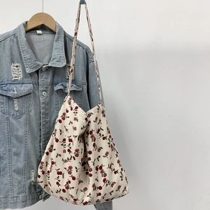 Detail of floral canvas tote bag showing the vintage red flower pattern and fabric texture