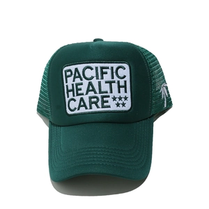 Detail of green mesh trucker hat with white coconut tree and Pacific Health Care embroidery