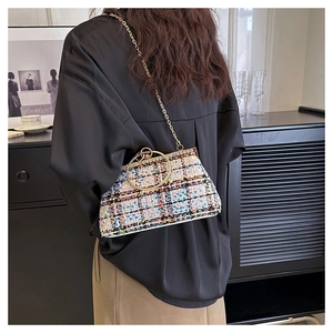 Fashionable colorful woven tweed handbag with large gold ring handle and chain strap on shoulder
