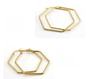 Detailed macro view of large golden hexagonal hoop earrings with high-polish mirror finish