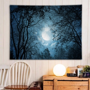 Detail of forest moon tapestry on wall with warm lamp light and wooden cabinet