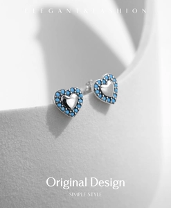 Detailed view of S925 sterling silver heart studs with turquoise beads on white stand