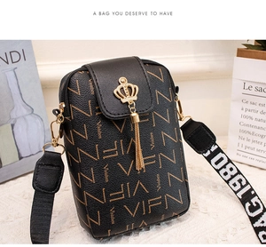 Detail of small black crossbody phone bag with gold crown, tassel and monogram pattern
