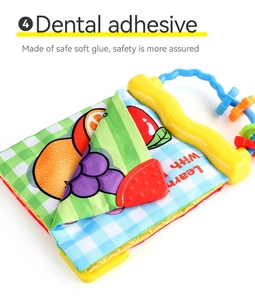 Detail of baby cloth book with fruit illustrations and a red textured teething ring