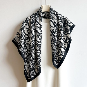 Elegant 90cm black and white letter D silk scarf accessory styled on a white dress