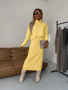 Détail de la texture en maille jaune vif sur l'ensemble haut à col roulé et jupe midi