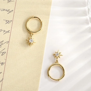 Detailed view of gold S925 sterling silver starburst hoop earrings with white zircon