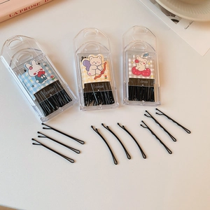 Detail of black wave-shaped hair clips in a portable illustrated cute storage case