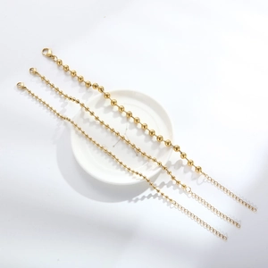 Detailed shot of three golden stainless steel bead chains with lobster clasps and extenders