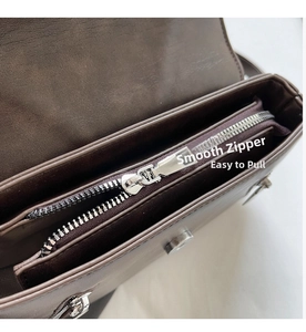 Detailed close-up showing smooth silver zipper closure on a vintage brown saddle bag