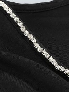 Detailed macro view of square crystal rhinestones on elegant black long sleeve dress fabric