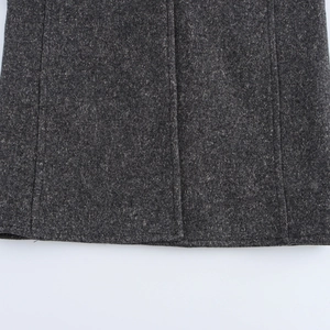 Close-up detail of dark grey wool blend fabric with professional stitching on coat