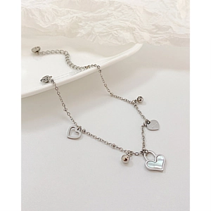 Close-up of silver heart pendants with shell inlay and Love engraving on link chain