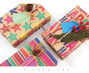 Detail of Happy Holiday kraft paper gift wrap with natural twine and pine cone decor