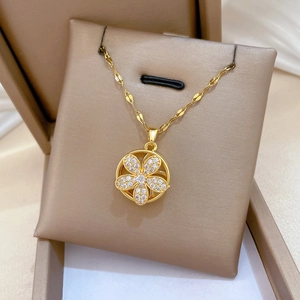 Detailed macro view of a gold-plated flower pendant with sparkling cubic zirconia inlay