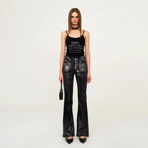 Ensemble chic pour femme avec jean flare scintillant et débardeur noir en studio