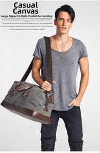 Detailed shot of large canvas travel bag in grey with brown leather accents and shoulder strap