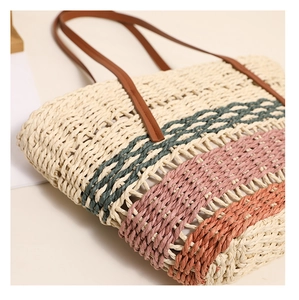 Détail d'un cabas en paille à rayures colorées avec texture tissée et anses cuir