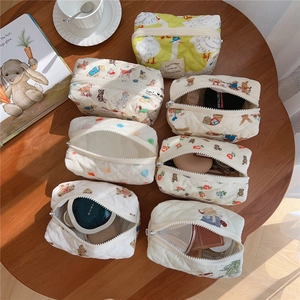 Quilted cotton cosmetic bags with cute bear prints and zipper closure on a wooden table