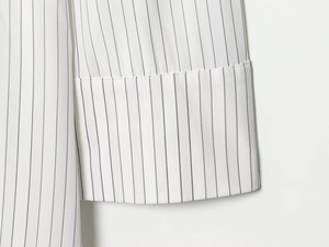 Close-up of white and black striped long sleeve cuff showing high-quality woven texture