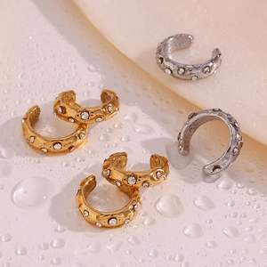 Detail of gold and silver C-shaped ear cuffs featuring sparkling white zircons and water drops