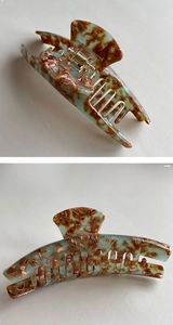 Macro detail of tortoiseshell acetate shark hair clip with a durable gold metal spring