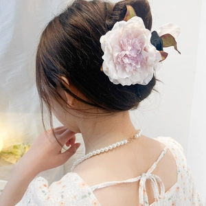 Pink fabric rose hair claw clip with crystal detail on model's elegant updo
