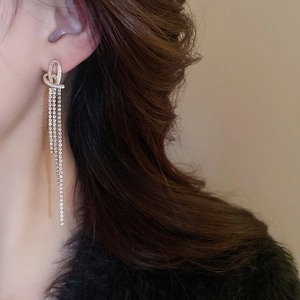 Detail of silver needle knot heart earrings with long tiered tassels and cubic zirconia