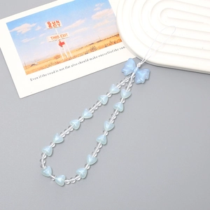 Detail of blue bow and frosted heart beads on a beaded phone wrist strap with clear accents