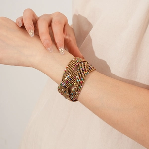 Détail d'un bracelet manchette bohème multicouche avec perles de verre colorées au poignet