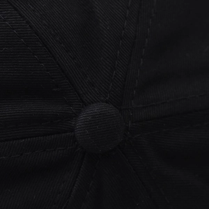 Macro shot of the black cotton baseball cap top button and detailed twill fabric texture
