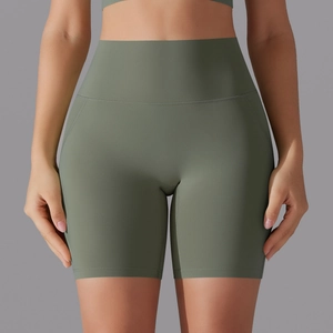 Front view of olive green high-waisted yoga shorts with seamless wide waistband on model