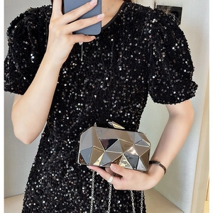 Shiny geometric metal evening clutch bag with chain strap for women shown by a model