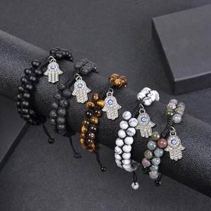 Cinq bracelets en perles avec pierre de lave, oeil de tigre et main de Fatma sur support