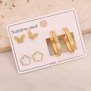 Close-up of a three-pair stainless steel earring set with gold butterfly and floral studs