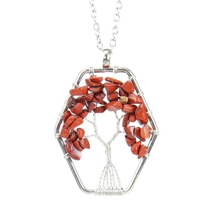 Macro shot of handmade silver wire-wrapped Tree of Life pendant with red jasper stones