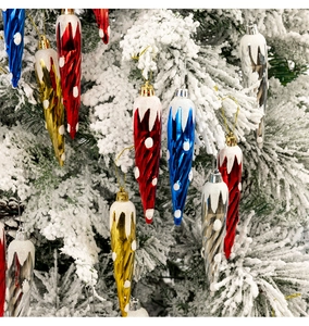 Ornamenti a spirale colorati con finitura metallica su un ramo di albero di Natale innevato