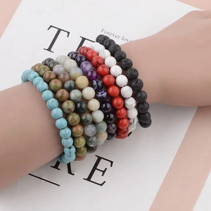 Stack of 8mm natural stone beaded bracelets including tiger eye and agate on a wrist