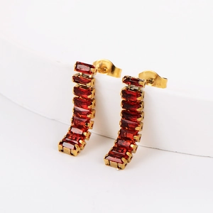 Detail shot of golden curved earrings featuring rectangular red zircon gemstones