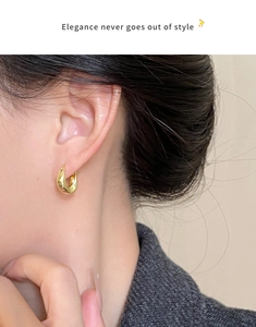 Close-up of model wearing minimalist 18K gold plated U-shaped drop earrings